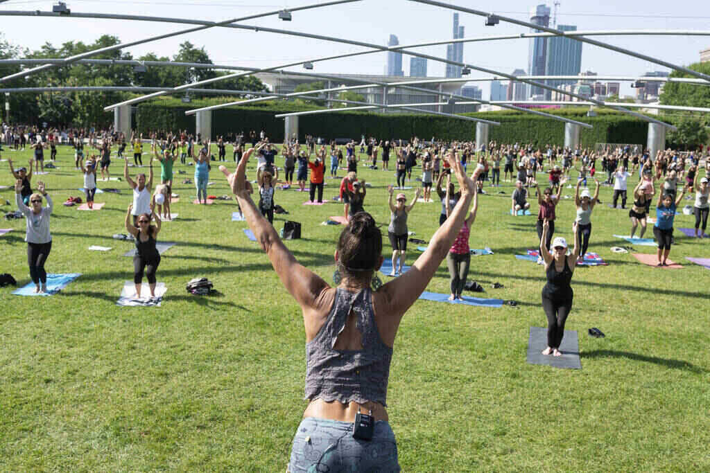 Free workouts in Millennium Park every summer.  - image of a group of people in a park